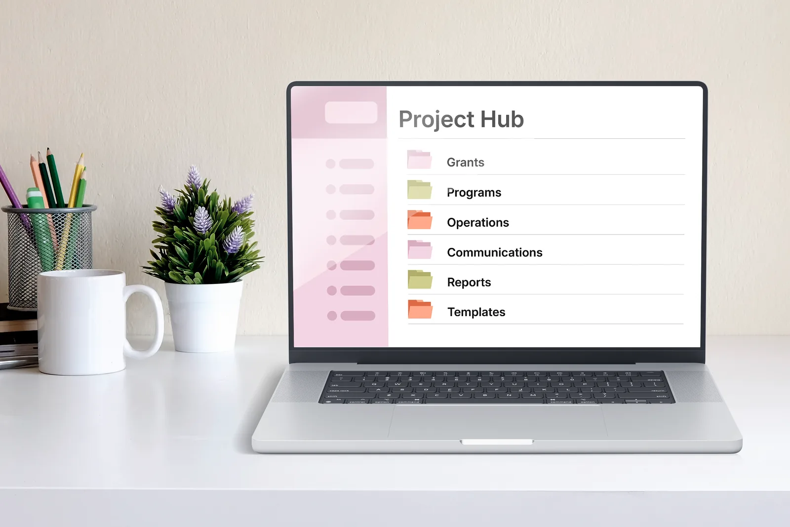 A laptop on a bright desk showing an organized Project Hub, with folders for Grants, Programs, Operations, Communications, Reports, and Templates.